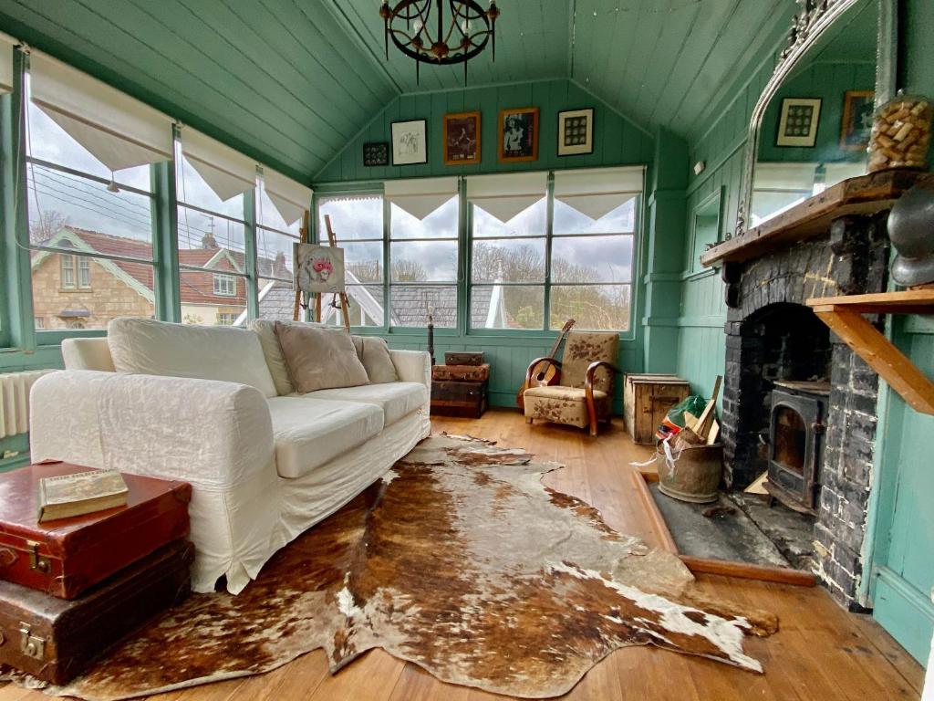 a living room with a white couch and a fireplace at Artist's Retreat - Old Signal Box - Private Sauna in Bath