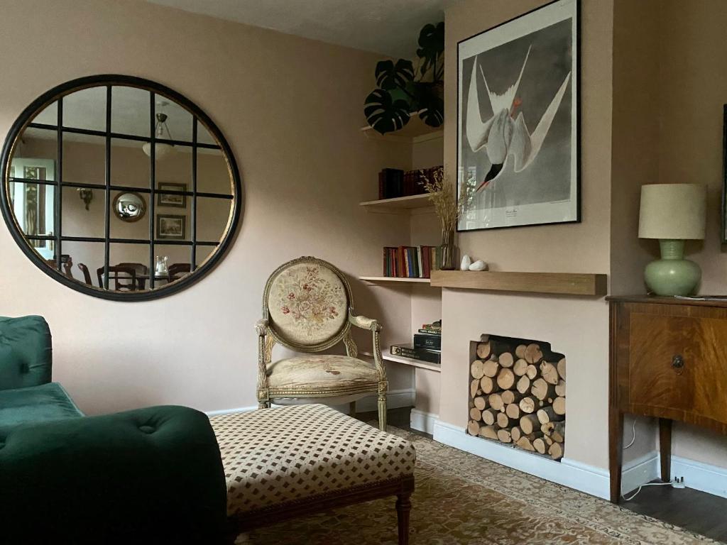 een woonkamer met een stoel en een spiegel bij Historic Family Cottage - Central Frome in Frome