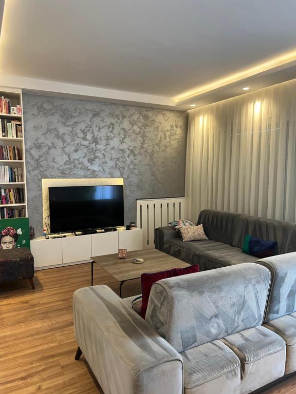 a living room with two couches and a flat screen tv at Ani’s apartment in Pristina