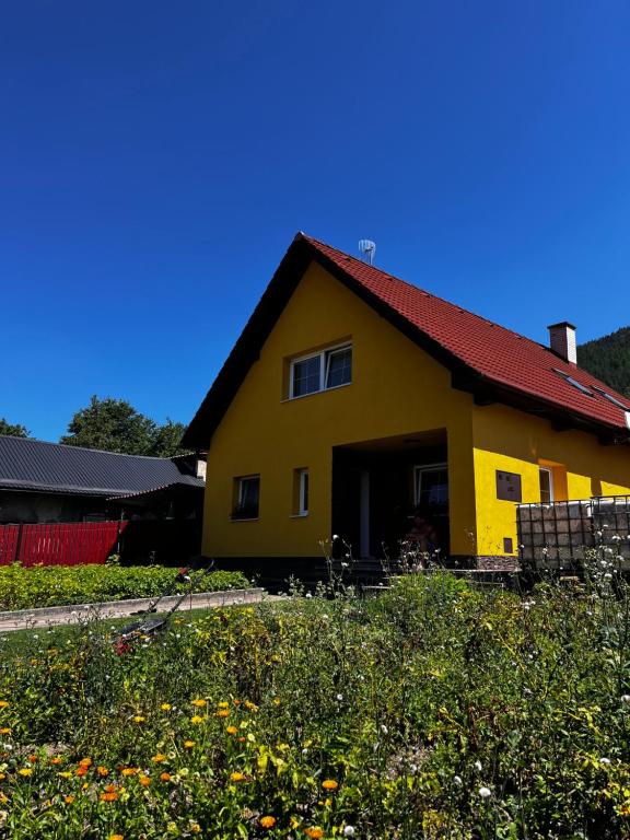 una casa amarilla con techo rojo en Dovolenkovy dom en Ružomberok