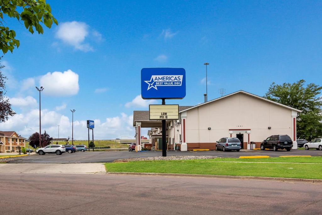 a sign for a gas station in a parking lot at Americas Best Value Inn Fargo in Fargo