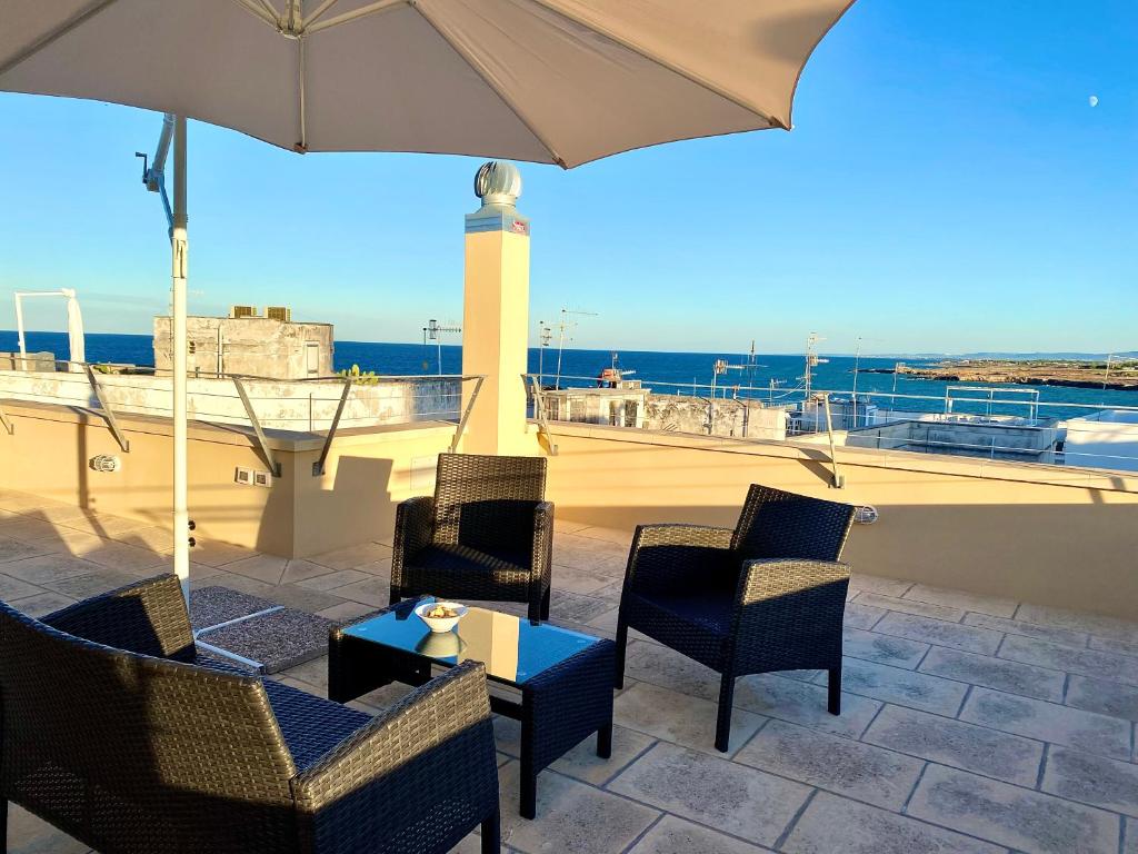 a patio with chairs and a table and an umbrella at Dimore San Giovanni - Puglia Mia Apartments in Monopoli