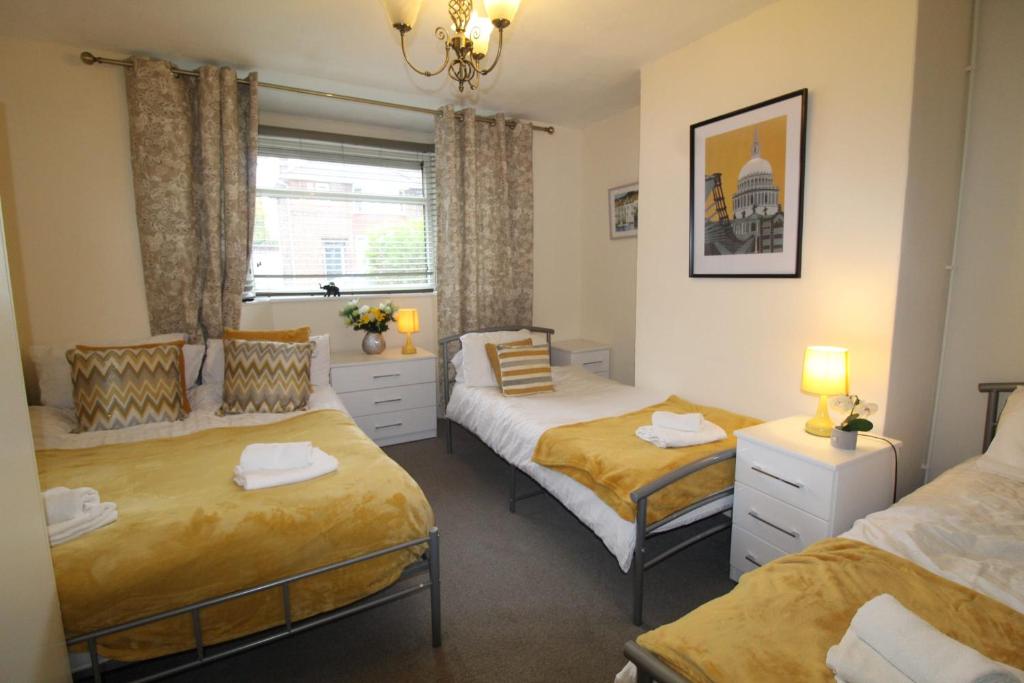 Un dormitorio con dos camas y una ventana. en Clifton House, en Woodhouse