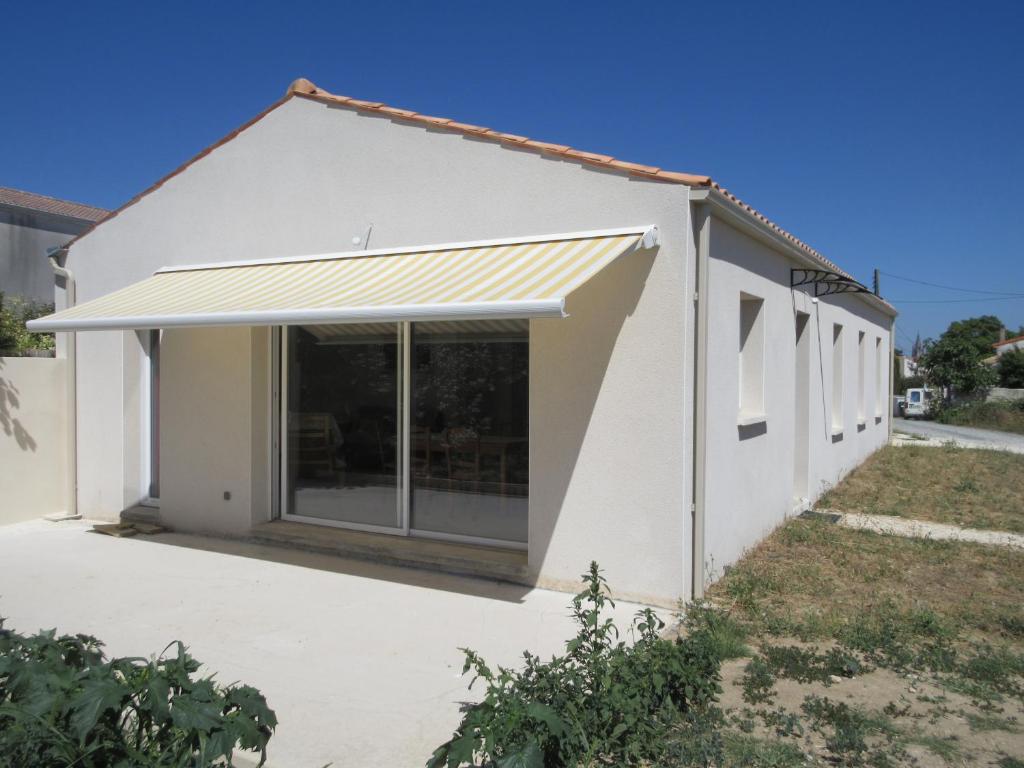 ein weißes Haus mit einer großen Glasschiebetür in der Unterkunft Maison neuve dans Saintes avec terrasse et jardin in Saintes