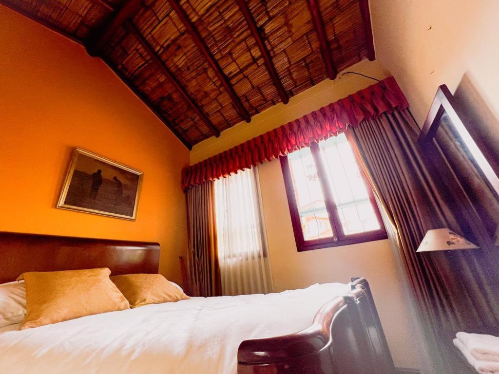 Schlafzimmer mit einem Bett und einem Fenster in der Unterkunft Casa Posada Maestro Carlos Aranguren in Duitama