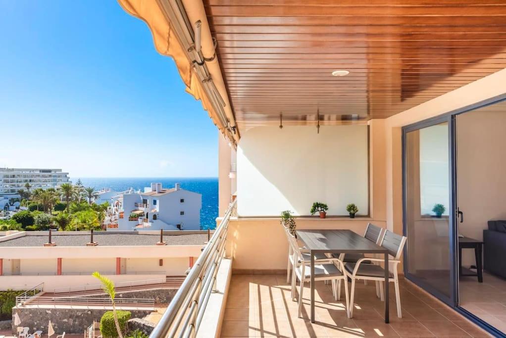 a balcony with a table and chairs and a view of the ocean at Bright and welcoming holiday home in Puerto de Santiago
