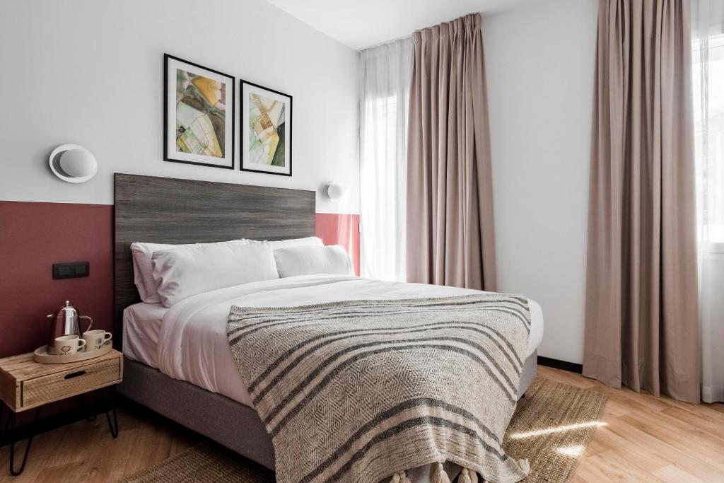 een slaapkamer met een groot bed en een raam bij Bob W Arte in Madrid