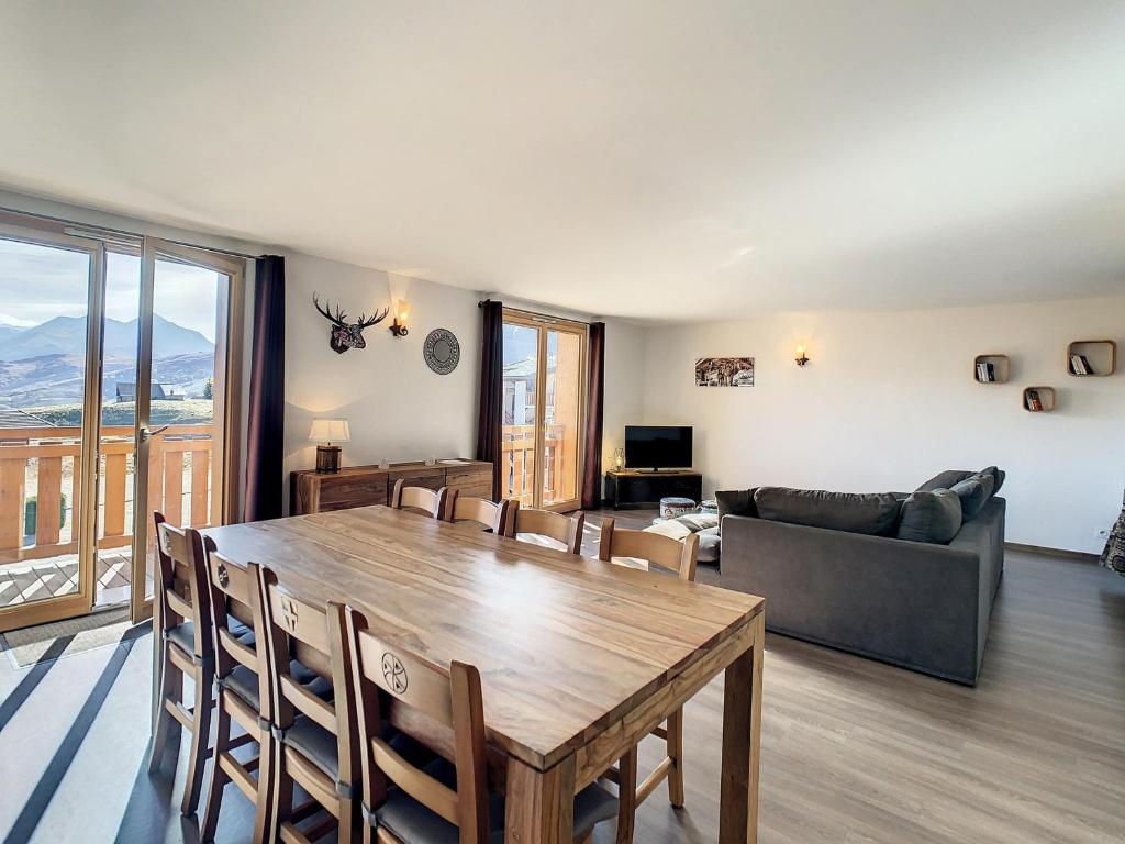un salon avec une table et un canapé dans l'établissement Appartement 2* 8 pers, proche télésiège, balcon sud, parking, commerces à proximité - FR-1-417-17, à La Toussuire