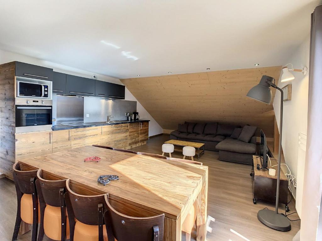 un soggiorno con tavolo in legno e una cucina di Appartement La Toussuire, 3 pièces, 6 personnes - FR-1-417-47 a La Toussuire