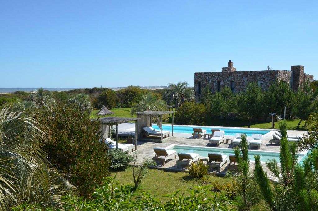 a villa with a swimming pool and a building at Casa Suaya in José Ignacio