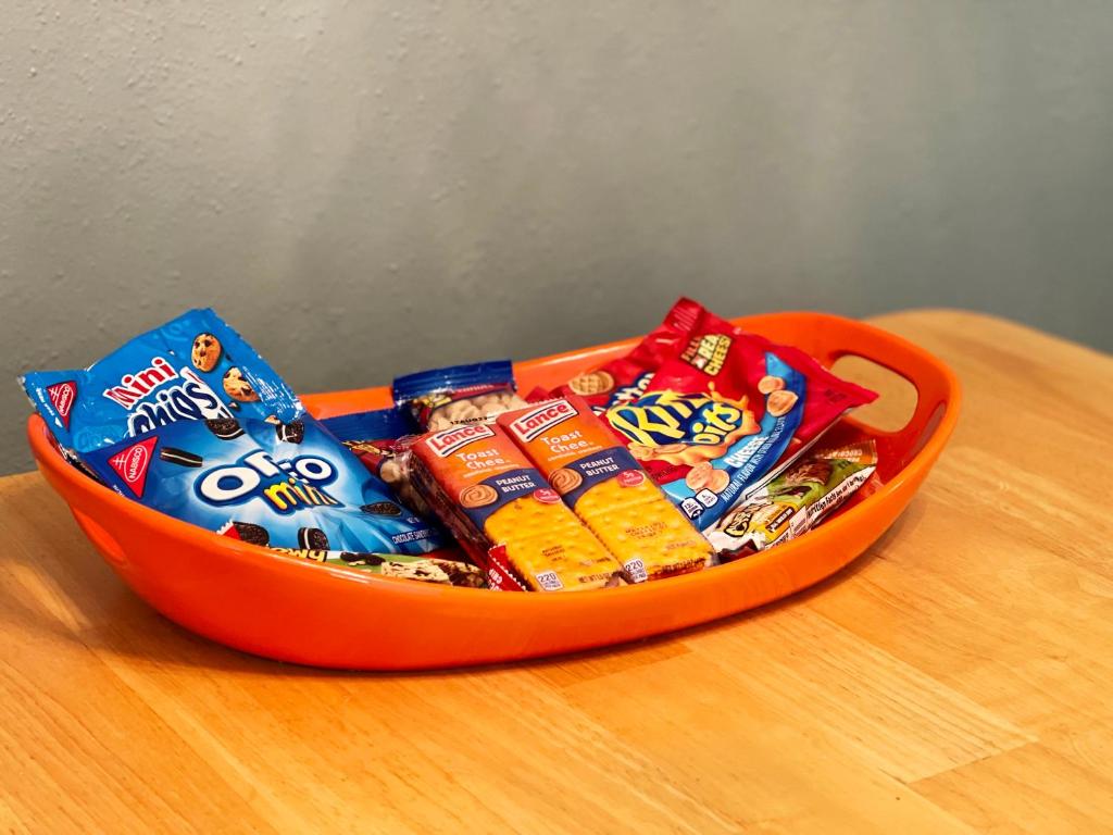 an orange container filled with chips and snacks on a table at New Family Friendly Stay! No Checkout Work! in College Station