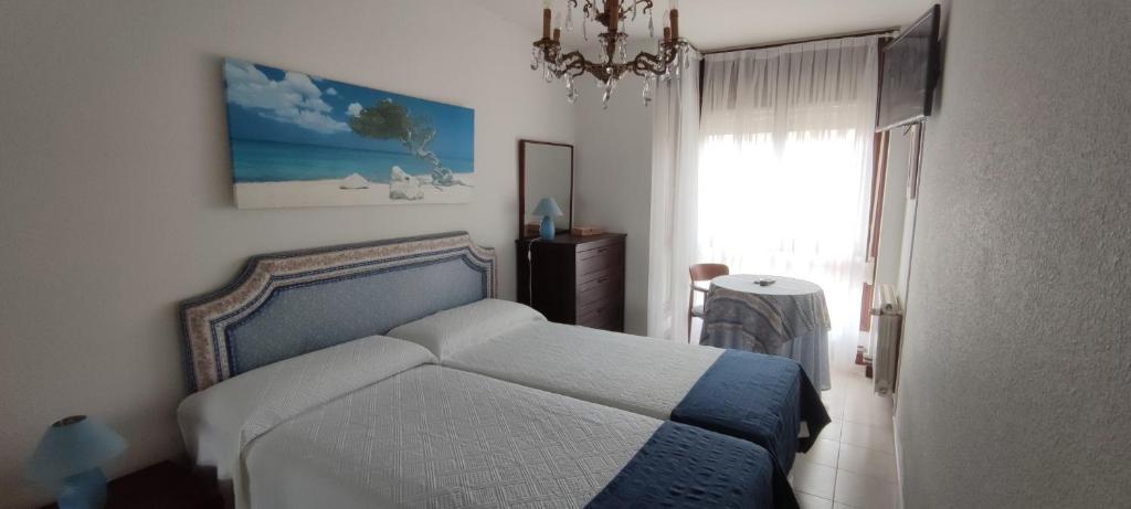Кровать или кровати в номере Acogedor apartamento en la playa de Trengandín también para tu mascota