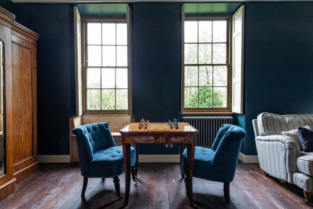 a room with blue walls and a table and chairs at Hillside House - beautiful 16th century house with Wifi, Parking, games room, Netflix in Oakhill