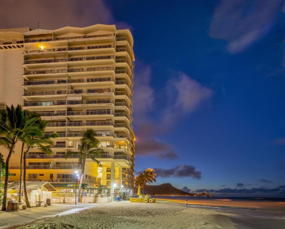a large building on the beach at night at Castle Waikīkī Shore in Honolulu
