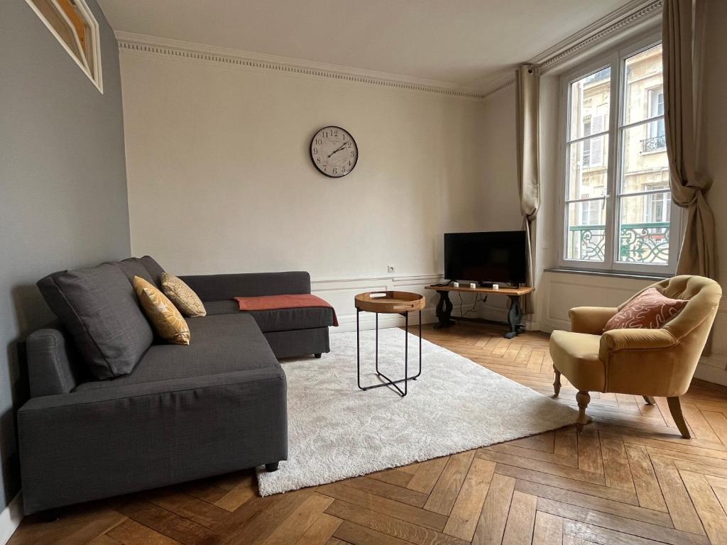 a living room with a couch and a tv at APPARTEMENT COSY CENTRE HISTORIQUE in Caen