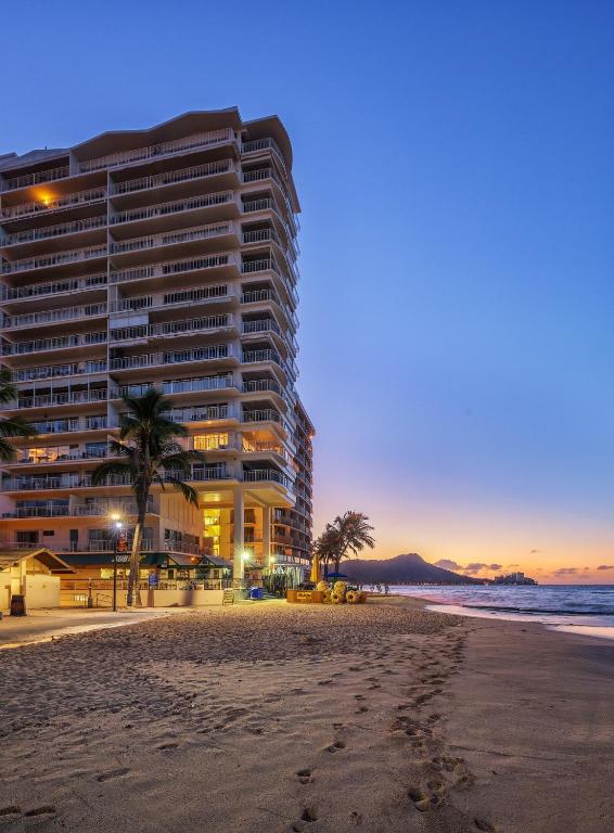 a large building on the beach with palm trees at Castle Waikīkī Shore in Honolulu