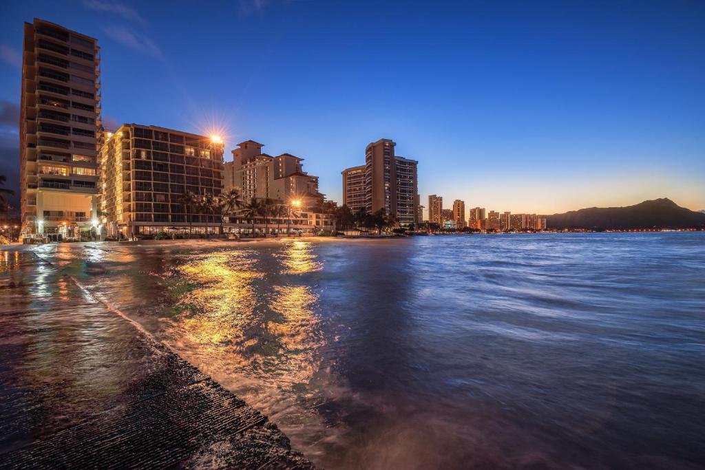 a large body of water with a city at night at Castle Waikīkī Shore in Honolulu