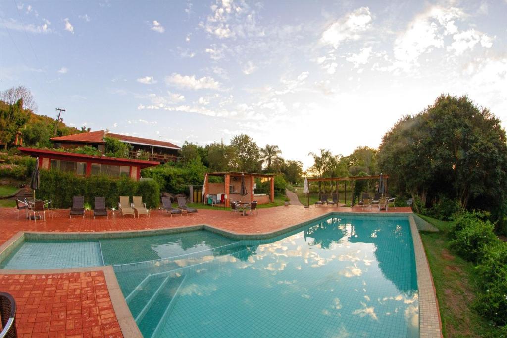uma piscina num quintal com uma casa em Hotel Fazenda Vale Alvorada em Cascavel