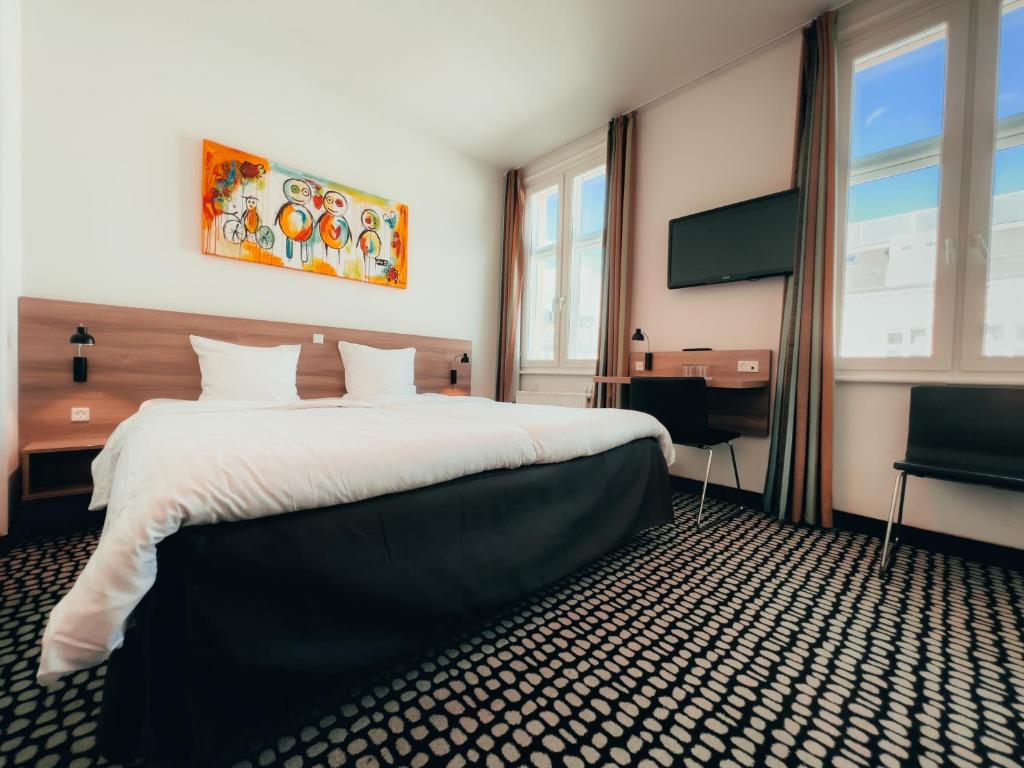 um quarto de hotel com uma cama e uma televisão de ecrã plano em Good Morning City Copenhagen Star em Copenhaga