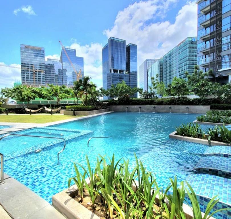 a large swimming pool with a city skyline in the background at Uptown Parksuites Tower 1 BGC in Manila