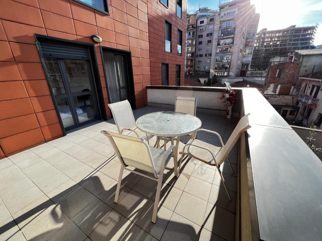 a patio with a table and chairs on a balcony at Grande Veranda 2 in Tirana