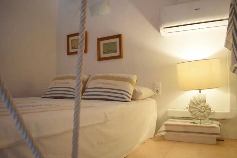 ein Schlafzimmer mit einem Bett mit einer Lampe und einem Bett mit einem sidx sidx sidx in der Unterkunft Isla de Tabarca: Casa Trinacria in Tabarca