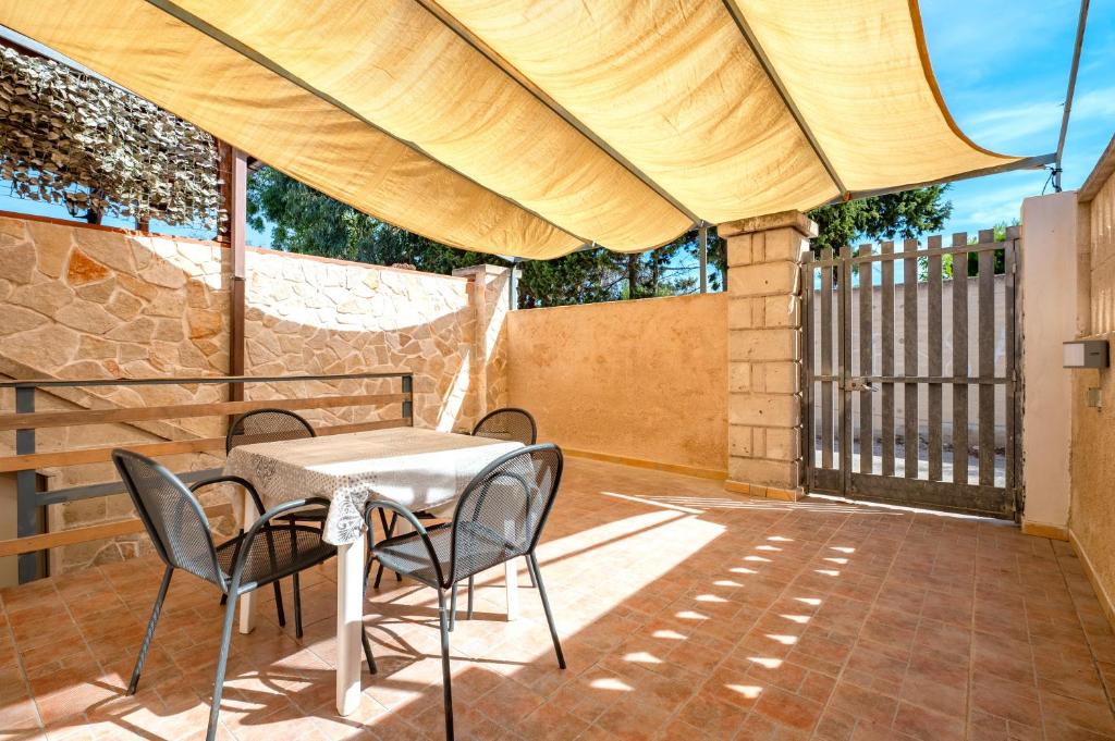 a patio with a table and chairs and a fence at Appartamento Acquadolce in Torre Ovo