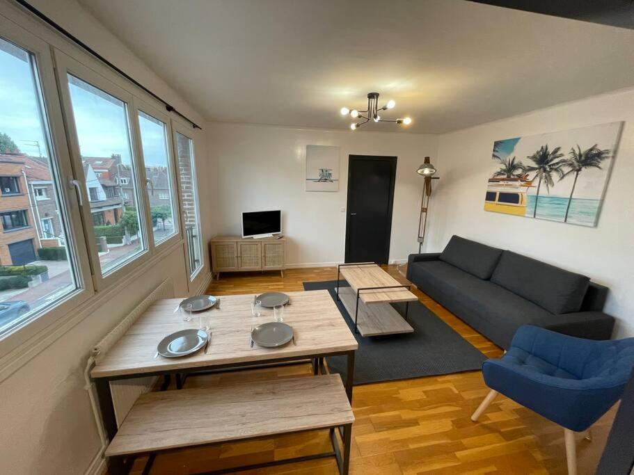 uma sala de estar com um sofá e uma mesa em croisé laroche 3 em Marcq-en-Baroeul
