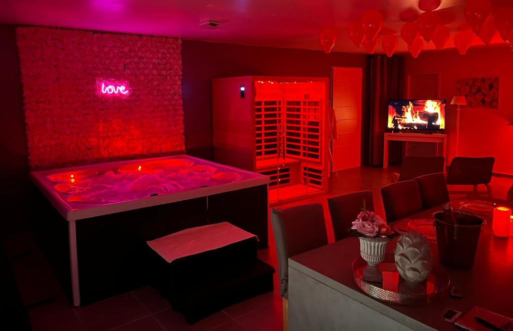 a red room with a hot tub and a table at Nid’Ange in Piolenc