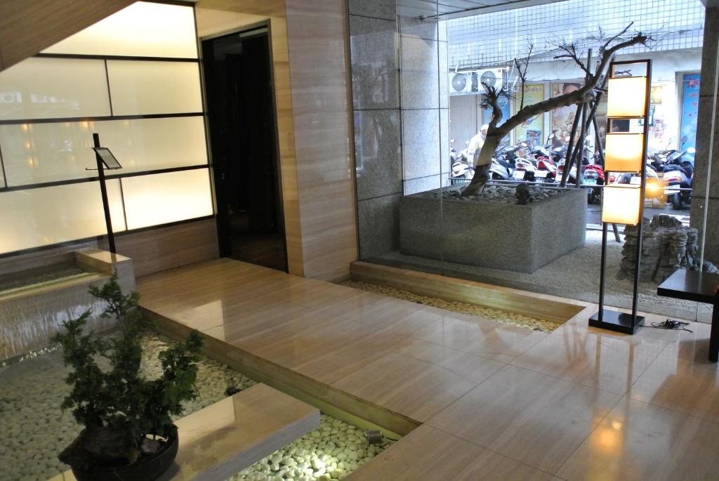 a lobby with a tree in the middle of a building at City Suites-Taipei Nanxi in Taipei