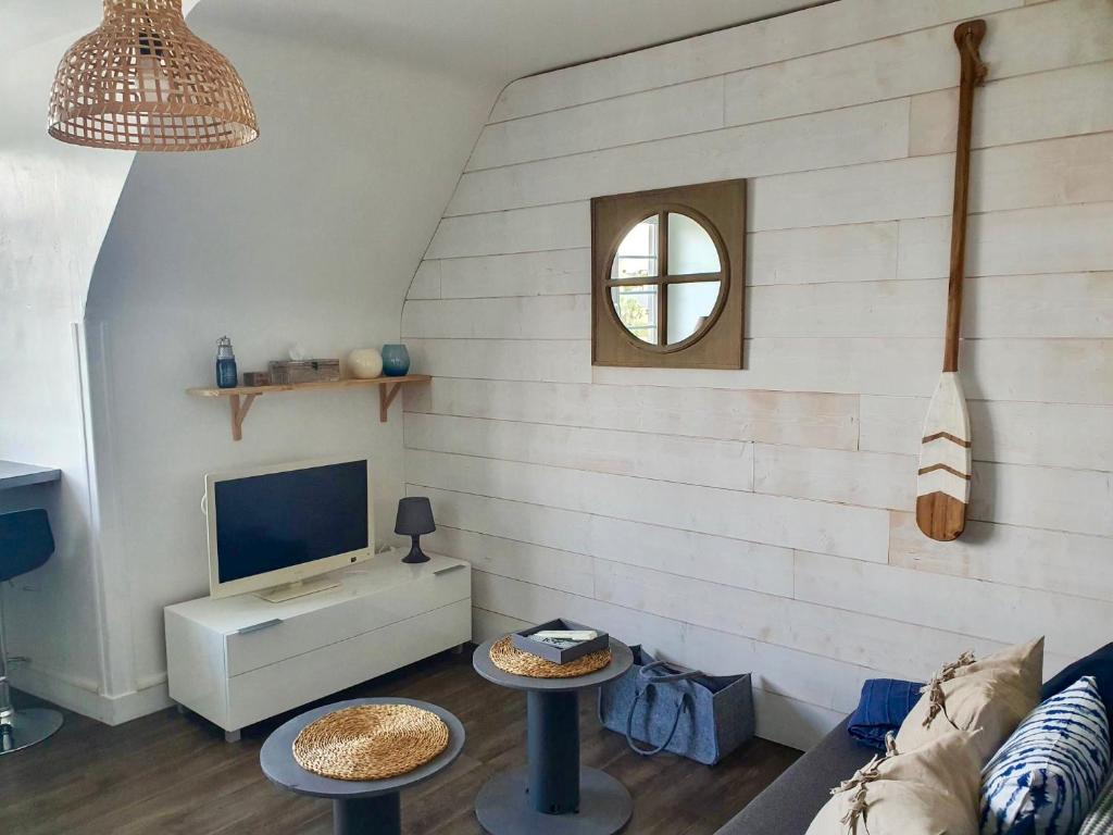 - un salon avec un canapé et une télévision dans l'établissement Vue Sur Mer, à Port-en-Bessin-Huppain