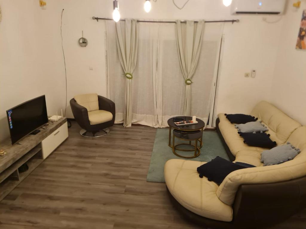 Una sala de estar con dos sofás y un televisor. en The FFG House - Appartements meublés Douala Cite des palmiers, Bonamoussadi, en Douala