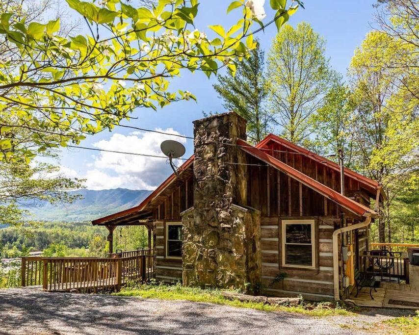 a log cabin in the woods with a stone chimney at R&R Retreat in Sunshine