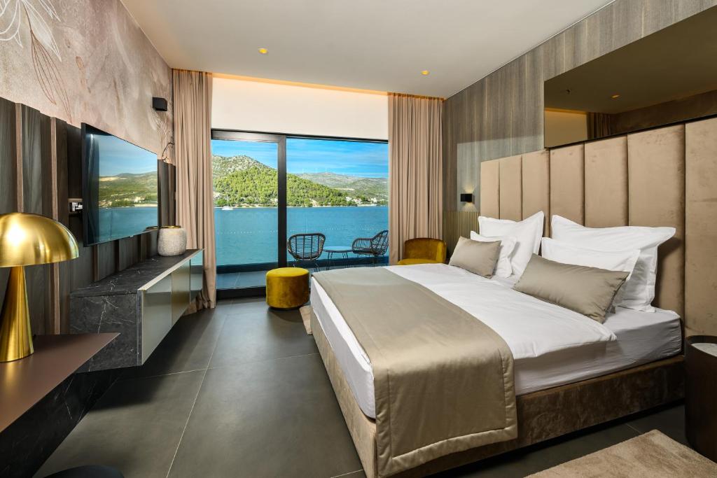 Schlafzimmer mit einem großen Bett und Blick auf das Wasser in der Unterkunft Marinus Beach Hotel in Marina