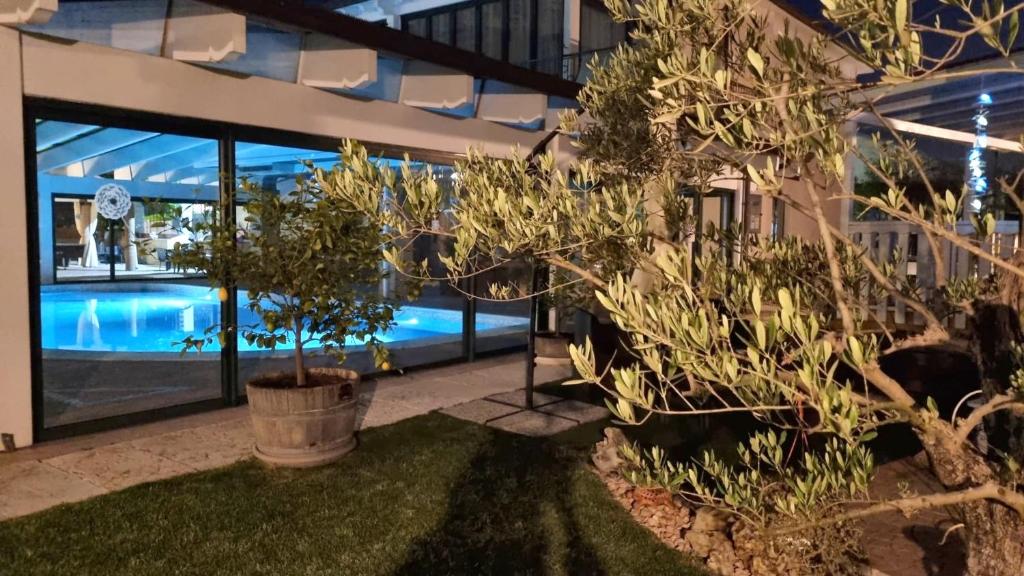 uma casa com piscina e árvores no quintal em NEW! Suite Apartment em Castelnuovo del Garda