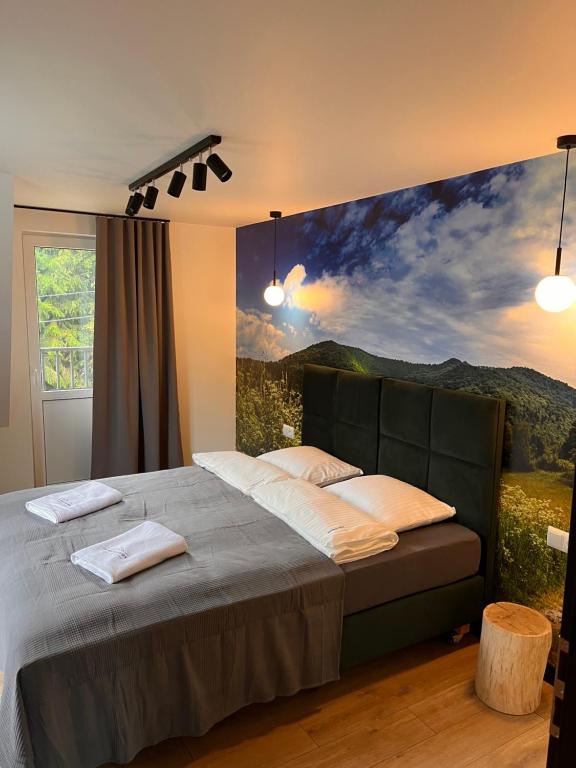 a bedroom with a bed with a painting on the wall at Apartamenty i Chata Drewno i Kamień in Wetlina