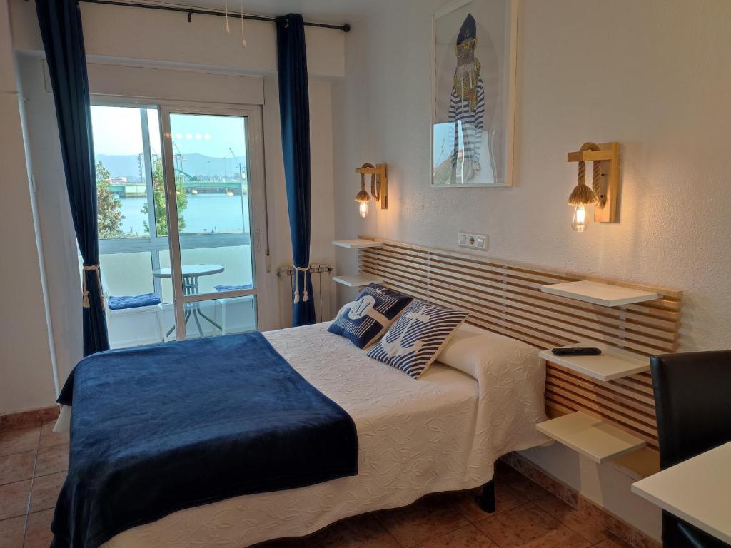 a bedroom with a large bed and a balcony at Hostal Lucy in Santander