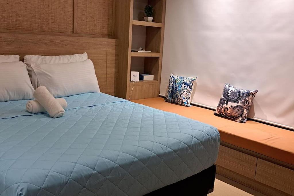Un dormitorio con una cama azul con almohadas. en Lovely condo near NAIA terminal 3, en Manila
