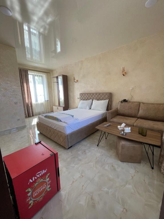 ein großes Schlafzimmer mit einem Bett und einem Sofa in der Unterkunft Hayots Ojakh in Sewan