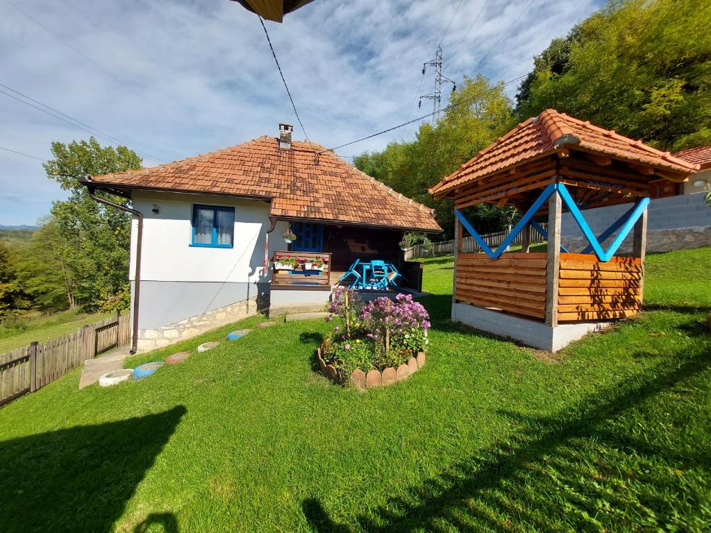Seosko domaćinstvo Alababa في Kosjerić: منزل صغير مع شرفة في الفناء