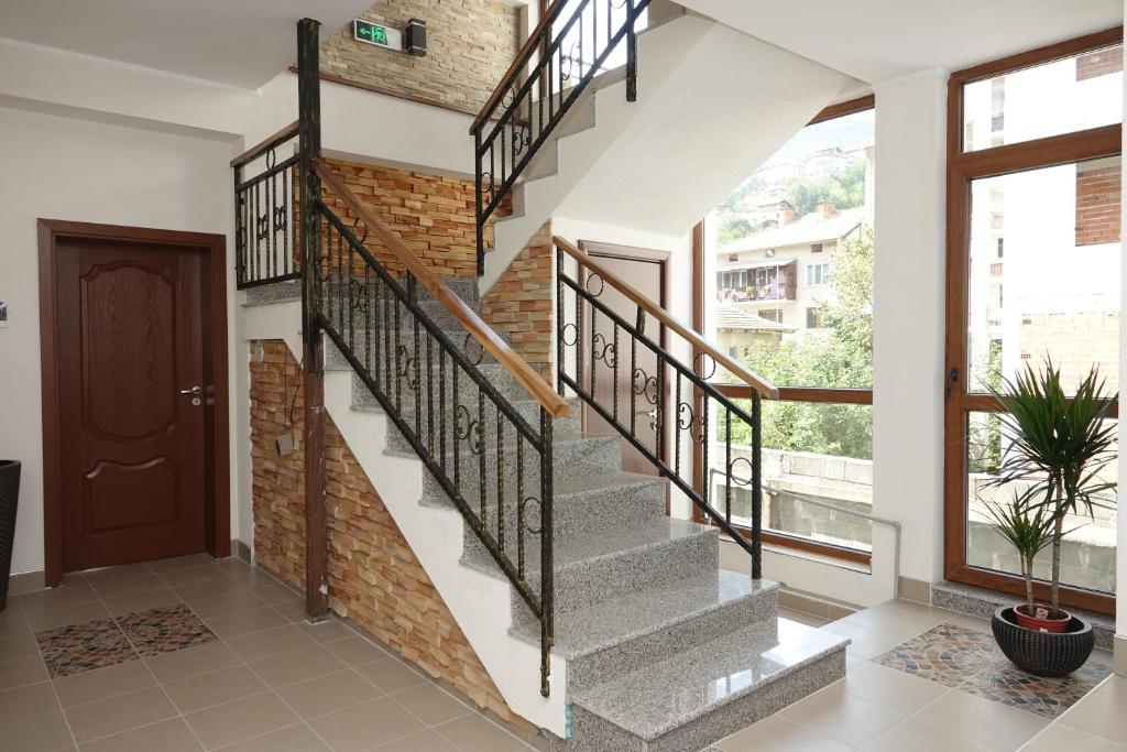 eine Treppe in einem Haus mit Ziegelwand in der Unterkunft Стаи за гости RADEA in Dewin