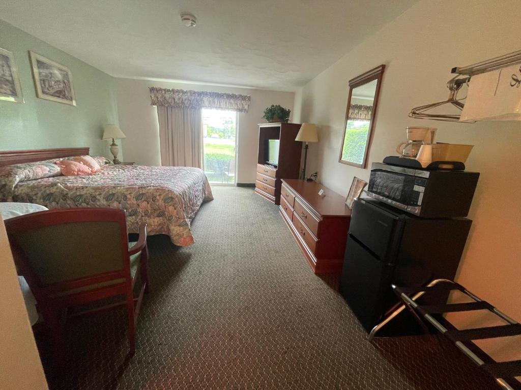 a hotel room with a bed and a television at Colonial Brick Inn & Suites in Susquehanna