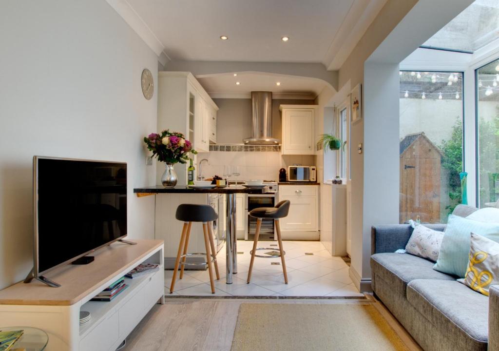 een woonkamer met een bank en een keuken bij Maisies Place in Brighton & Hove