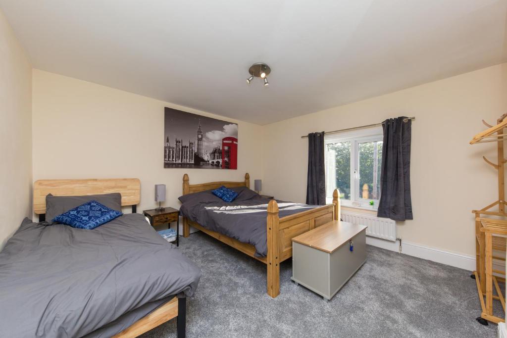 - une chambre avec 2 lits et une fenêtre dans l'établissement Rocester Rest close to Alton Towers & JCB, Netflix, à Rocester
