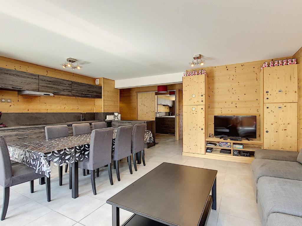 a living room with a table and chairs and a tv at Magnifique appartement 3 chambres, balcon sud, parking, non-fumeur - FR-1-416-75 in La Toussuire