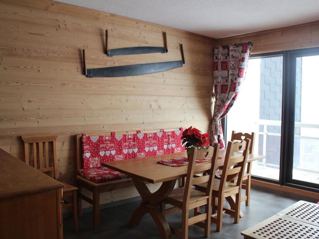een eetkamer met een houten tafel en stoelen bij Appartement lumineux 6 pers, 2 ch, départ ski au pied - FR-1-416-94 in La Toussuire