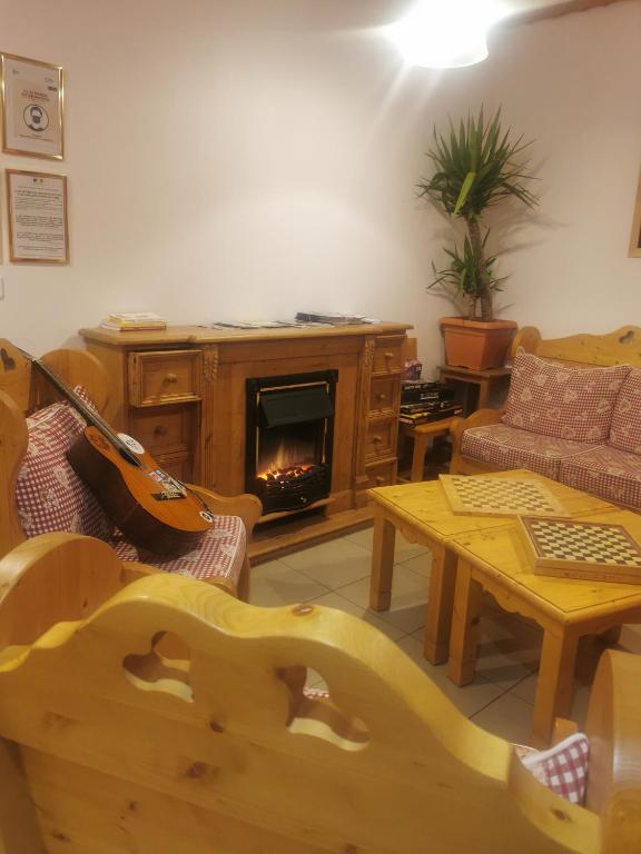 a living room with a guitar and a fireplace at Auberge du Freney in Le Freney-dʼOisans