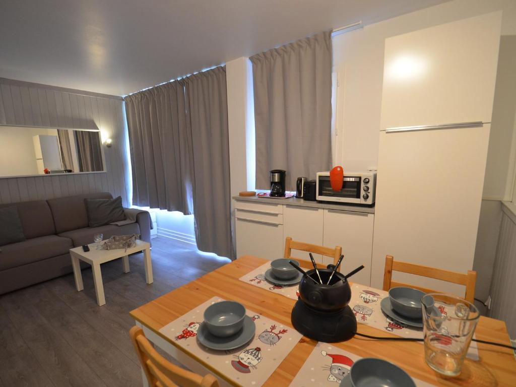 a kitchen and living room with a table and a couch at Studio Les Menuires, 1 pièce, 4 personnes - FR-1-452-2 in Les Menuires