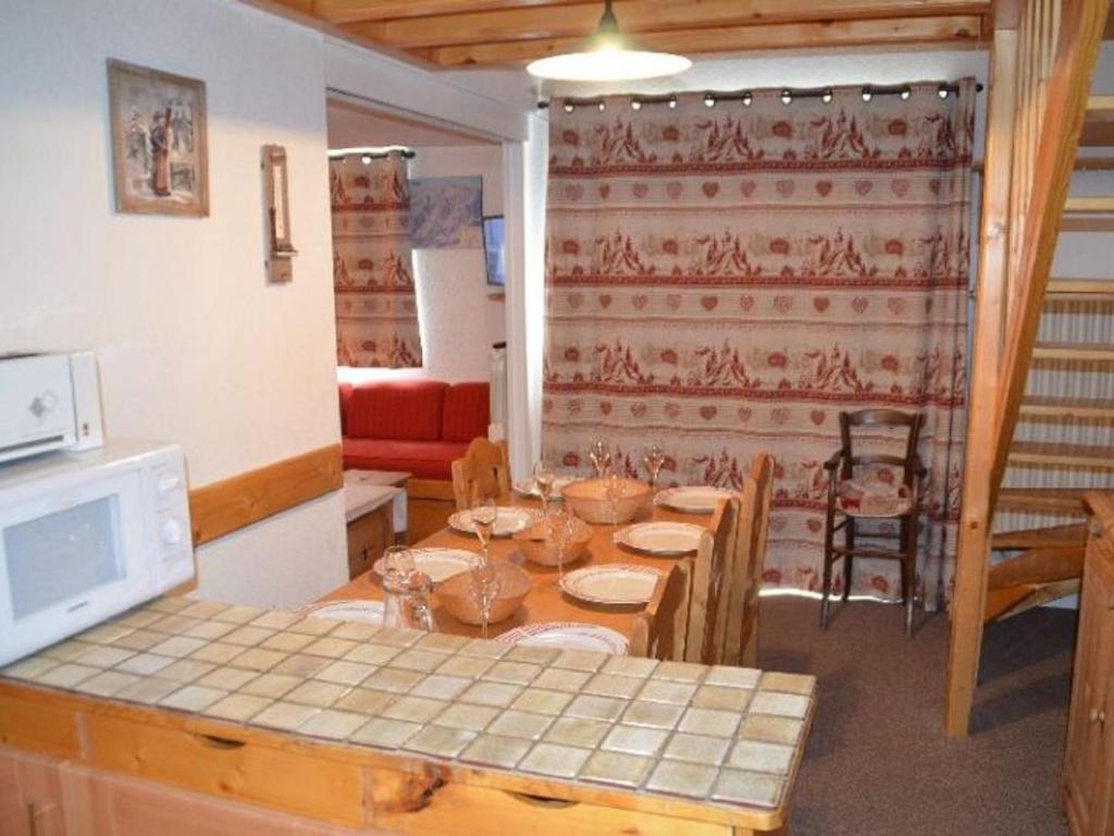 uma sala de jantar com uma mesa e algumas cadeiras em Appartement Les Menuires, 2 pièces, 7 personnes - FR-1-452-30 em Les Menuires