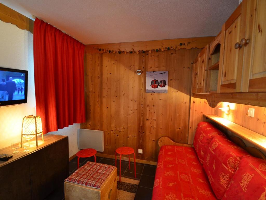 Habitación con sofá rojo y cortina roja en Studio Les Menuires, 1 pièce, 4 personnes - FR-1-452-22, en Les Menuires